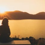 woman watching sunset by lake