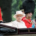 The Queen of England rides in a carriage