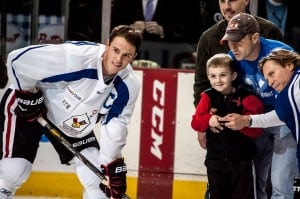 Friendly face-off: Former Ronald McDonald House guest Jeremiah King drops the puck in a face-off between NHL players Jonathan Toews (l) and Kimmo Timonen (r). Last summer, Jeremiah was hit by a car while training for a 5K run with his family.