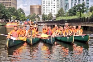 March Communications employees take a canoe ride on the Charles River in Boston as part of the public relations agency’s 2013 summer outing.  