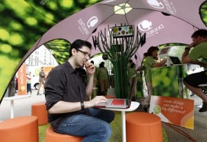 A visitor to DoubleTree by Hilton’s Little Things Project event in New York City enjoys one of the brand’s signature chocolate chip cookies while taking advantage of the free Wi-Fi offered by the hotel chain. 