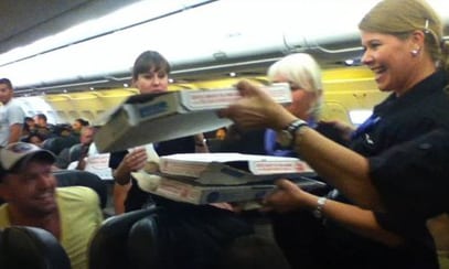 A passenger sent NBC 9NEWS this photo of Frontier crew handing out pizza aboard the delayed flight. (Photo: Logan Marie Torres)