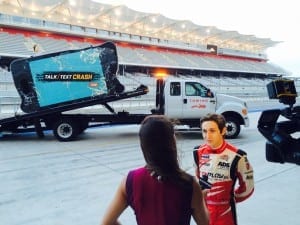 Zach Veach talks to a reporter in front of a 950-pound crashed phone. Sherry Matthews Advocacy Marketing created the visual as part of TxDOT’s “Talk, Text, Crash” statewide, distracted driving public education campaign.