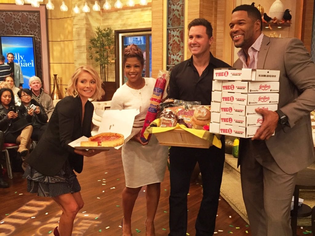 PIE HIGH: We’re sure Michael Strahan (right) easily can down those 6 deep-dish pies from Giordano’s, but it might take Kelly Ripa (left) all day to eat just one. “Windy City Live” hosts Val Warner (next to Kelly) and Ryan Chiaverini delivered the pizzas.