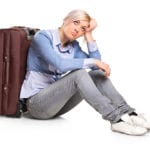 girl sitting by suitcase