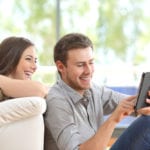 couple laughing at tablet