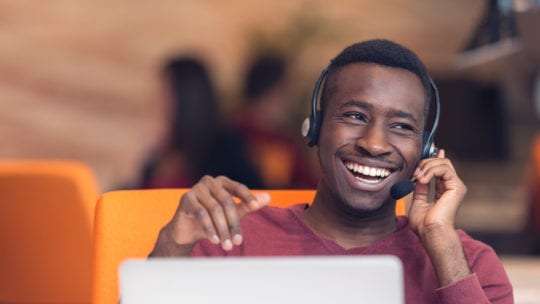 man on headset on latoptop