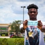 Quinton Desamours, former Publix employee, holds BLM mask in front of supermarket