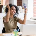 woman excited in front of laptop