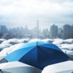 blue umbrella amid sea of white umbrellas