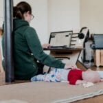 working mom on laptop with baby sleeping