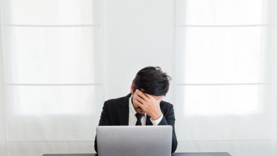 man frustrated at laptop