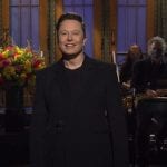 Elon Musk on SNL set, dressed in all black.