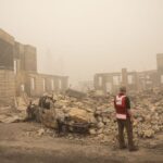 Red Cross volunteer surveying wildfire damage.