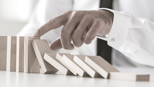 Businessman stopping domino