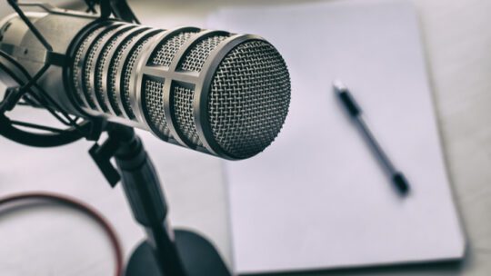ask a journalist image shows a microphone, paper and a pen
