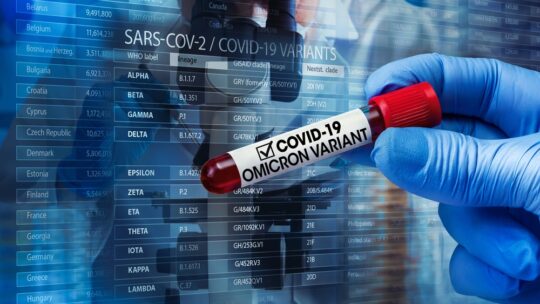 covid variant omicron in test tube being held by blue gloved hand