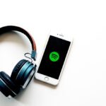 spotify app on phone next to headphones