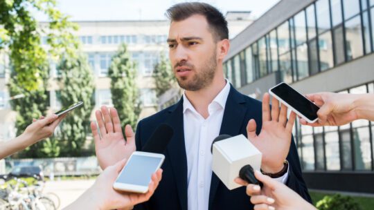 man silencing the press, saying off the record