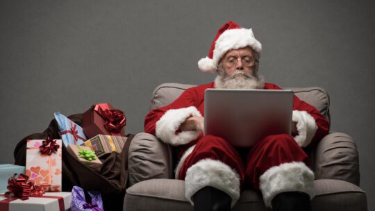 Santa responding to people on social media with his laptop