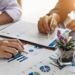 two people looking over charts and graphs for communications measurement