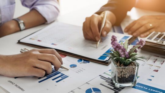 two people looking over charts and graphs for communications measurement