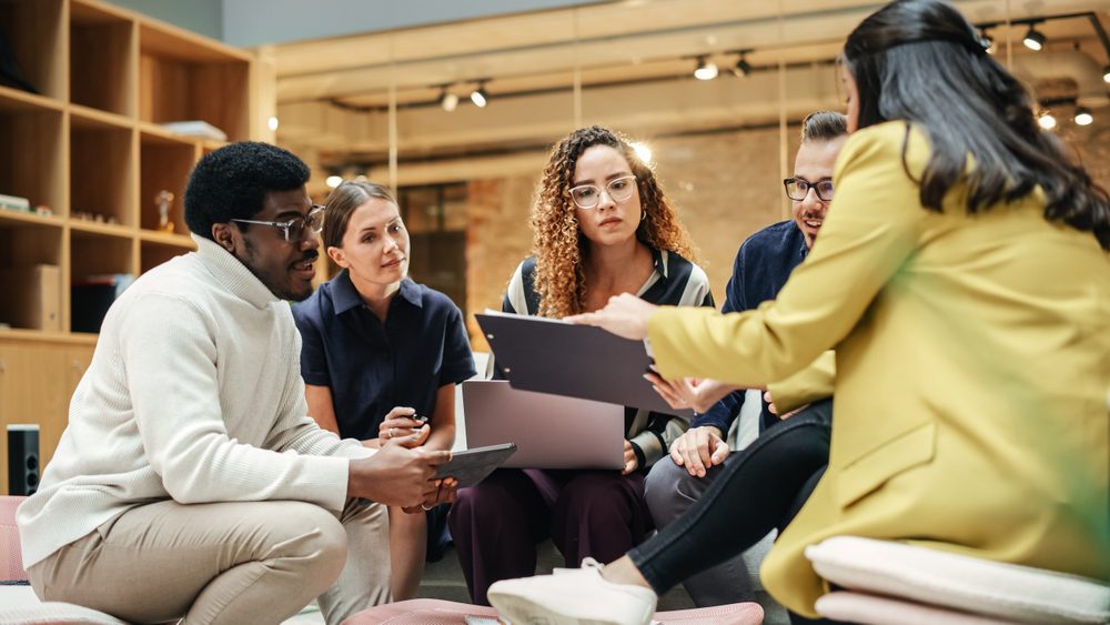 crisis team sits in a circle around a laptop