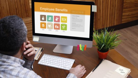 Man using computer with Employee Benefits concept on screen