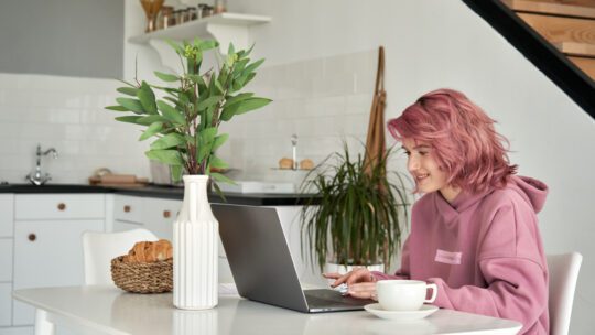 Gen Z working at a laptop at a kitchen table