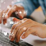 Social media and Marketing virtual icons screen concept.close up of businessman typing keyboard with laptop computer on wooden desk in modern office