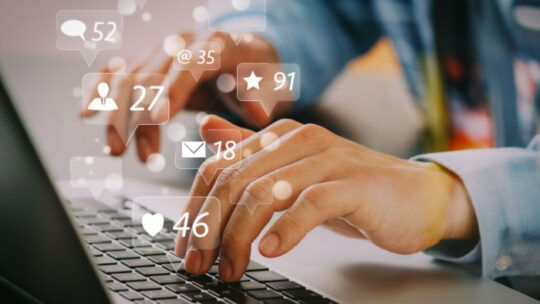 Social media and Marketing virtual icons screen concept.close up of businessman typing keyboard with laptop computer on wooden desk in modern office