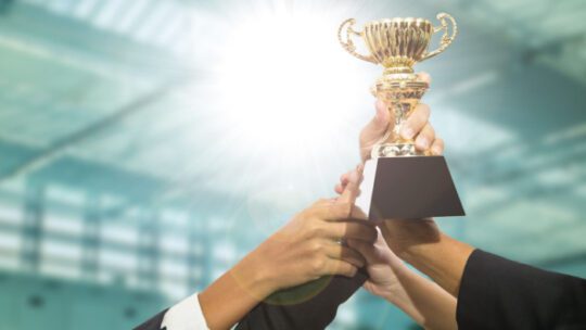 Businessman team holding award trophy for show their victory.