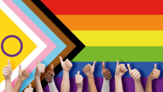 lgbtq, trans and intersex rights concept - multiracial human hands showing thumbs up over rainbow progress pride flag on background