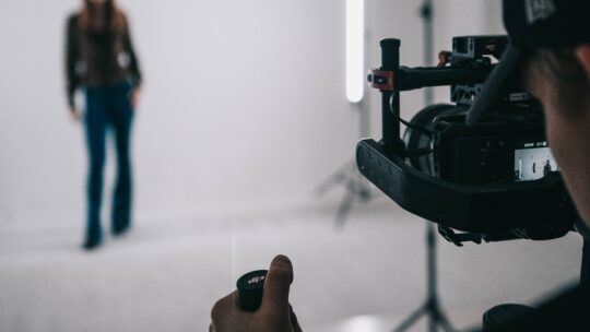 A male photographer taking a photo of the blurred silhouette of a model.