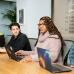 Professionals in a conference room, collaborating with laptops for productive meetings and teamwork.