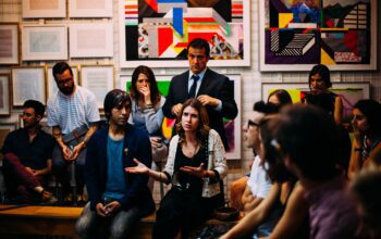 A diverse group of individuals seated in a circular arrangement, engaged in a lively and animated conversation, reflecting active communication and collaboration.