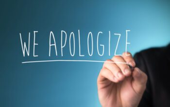 Male hand writing phrase we apologize you on virtual screen.