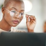 Office, computer and black woman with glasses, serious or reading email, news, online research or report.