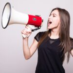 lady with brown hair shouting into megaphone, advocating for a brand