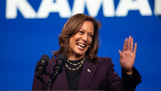 Democratic presidential candidate Kamala Harris waves to the crowd from the stage podium at a rally