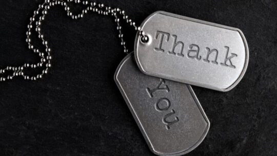 Old and worn military dog tags that Thank You to honor Veteran employees for Veterans Day