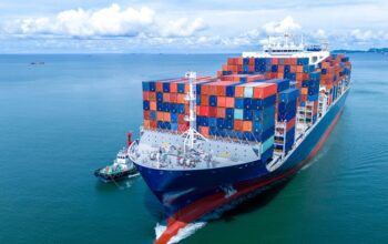 Front view of Cargo container ship carrying container and running out international container port customs shipyard sea port concept smart logistic service.