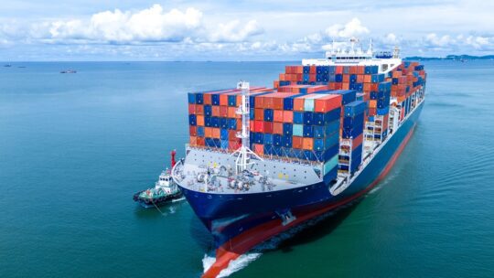 Front view of Cargo container ship carrying container and running out international container port customs shipyard sea port concept smart logistic service.