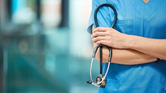 Nurse, woman and arms crossed for cardiology with stethoscope in clinic, support and healthcare. Female person, medical and tool to monitor heart in hospital, medicine and surgeon for treatment
