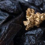 Gold Nugget mining from a pile of black rocks