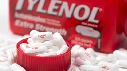 Bottle of Tylenol extra strength with many 500mg pills on white background, most common painkillers and fever reducer medicine in America