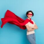 Photo of confident shiny lady dressed red mantle arms crossed cape flying isolated blue color background