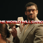 Bad Bunny in an Apple TV commercial for his super bowl halftime performance. He is dancing surrounded by a diverse group of people also dancing. The text says: The World Will Dance.