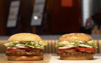 Two Whopper burgers from Burger King sitting side by side. One is the old version, one is the new version they are launching with a better bun and mayonnaise.