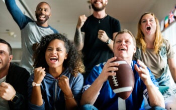 Friends watching on TV and cheering for Super Bowl together